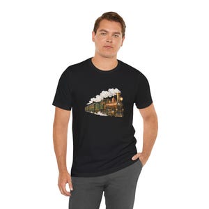 May include: A black short-sleeved t-shirt featuring a graphic print of a vintage steam locomotive train. The train is colored in shades of brown, gold, and green, emitting white smoke from its chimney while traveling along tracks.