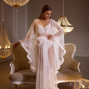 Bata de novia de tul transparente – Elegante prenda nupcial con volantes