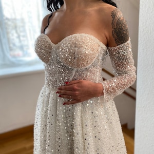 A-Line Off-the-Shoulder Wedding Dress with Corset Bodice Sequin Lace Long Sleeves High Slit Tulle Overskirt “Momke”
