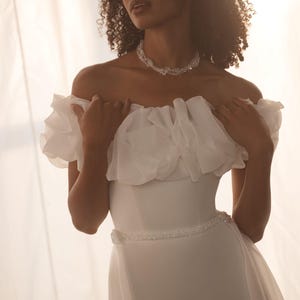 Robe de mariée à épaules dénudées : jupe ajustée en crêpe, traîne amovible en mousseline de soie