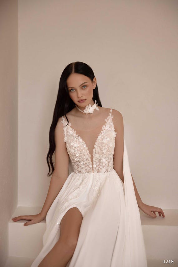 boho wedding dress 2025 A-line Deep V-neck Slit Appliques Sheer Corset Open Back Cape Wedding Gown “vaivore” Back Details 04/30/2026 Delivery Azazie Cora Bridesmaids Dress Size:Black