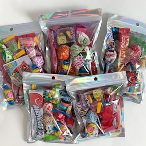 Pu&ograve; includere: Quattro sacchetti di plastica trasparenti pieni di varie caramelle colorate, tra cui lecca-lecca, caramelle gommose e cioccolato. I sacchetti sono iridescenti e hanno una chiusura a zip.