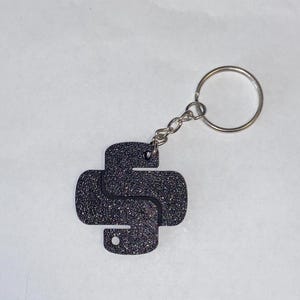May include: A black glitter Python logo keyring with a silver key ring.