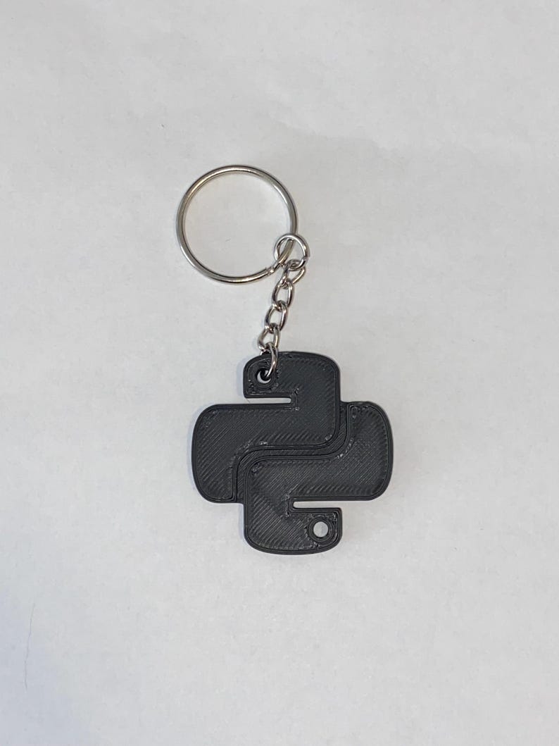 May include: A black 3D printed Python logo keyring with a silver metal key ring.