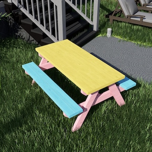 Peut inclure: Une table de pique-nique jaune avec des pieds roses et deux bancs bleus. La table et les bancs sont sur une pelouse.