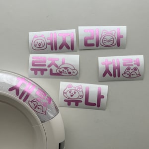 May include: Five pink vinyl stickers with Korean text and cartoon animal illustrations. The stickers feature a cat, a fox, and a monkey.