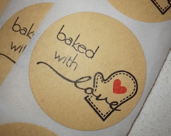 May include: Brown paper circle stickers with the text "baked with love" and a black and white illustration of a mitten with a red heart.