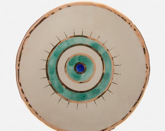 Plato artesanal con ojo turco, borde dorado, turquesa y un toque de azul oscuro.