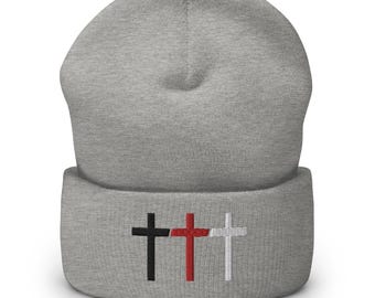 Puede incluir: Gorro gris con tres cruces bordadas en negro, rojo y blanco.