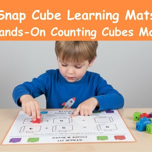 Könnte beinhalten: Ein Kind in einem blauen Hemd verwendet Snap Cube Learning Mats. Die Matte hat Zählprobleme mit Würfelbildern. Der Text auf der Matte lautet "Count & Build" und "Stack It!". Bunte Snap-Würfel liegen auf dem Tisch.