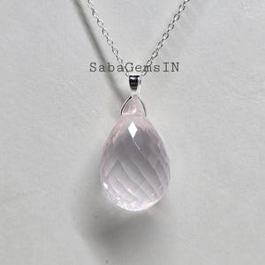 May include: A silver chain necklace with a pink rose quartz pendant. The pendant is faceted and has a teardrop shape.