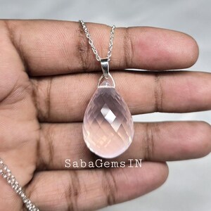 May include: A delicate silver chain necklace with a faceted pink quartz teardrop pendant. The pendant is approximately 1 inch in length and has a polished finish.