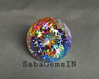 May include: A round, faceted gemstone with a vibrant display of colors, including red, orange, yellow, green, blue, and purple. The gemstone has a central starburst pattern and the text "Saba Gems IN" at the bottom.