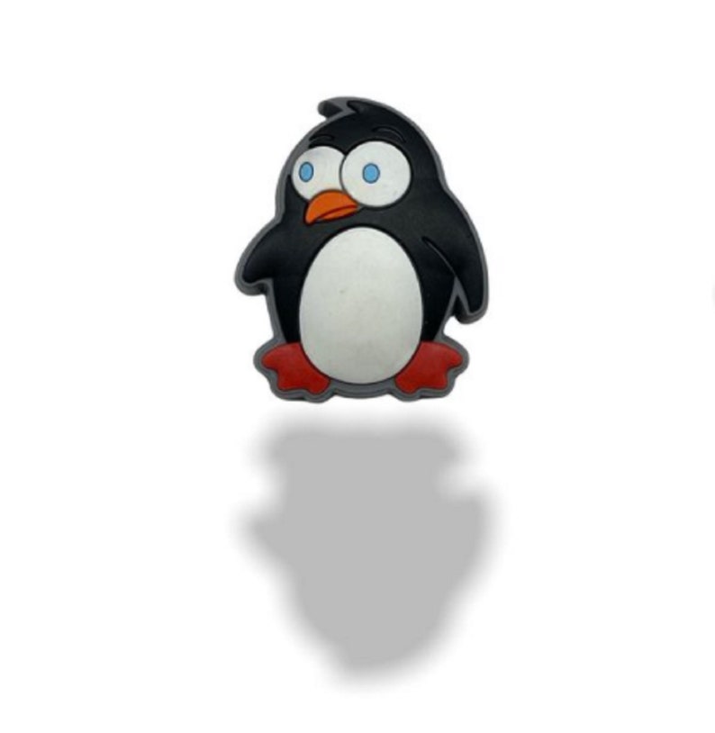 May include: A cartoon penguin charm with black and white feathers, red feet, and blue eyes. The penguin is standing upright with its wings at its sides.