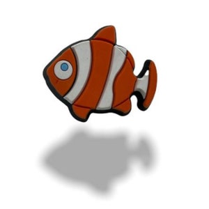 May include: Orange and white cartoon clownfish with a blue eye. The fish is made of rubber and has a 3D effect.
