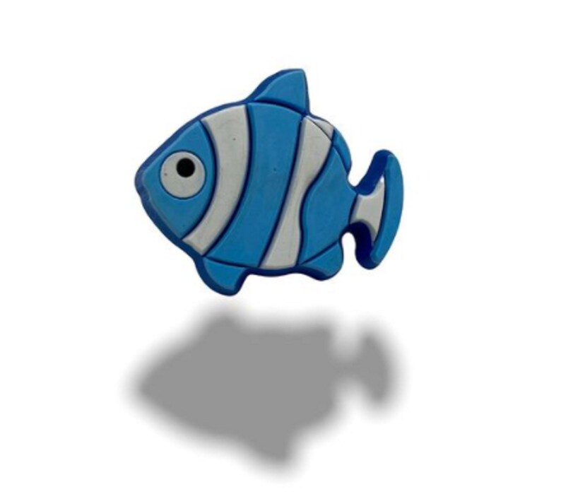 May include: A blue and white cartoon fish with a single black eye. The fish has a white stripe on its body and a white fin.