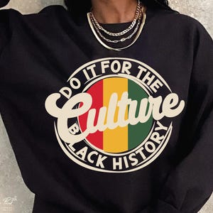 May include: Black sweatshirt with a graphic print of a red, yellow, and green circle with the text "Do It For The Culture Black History".