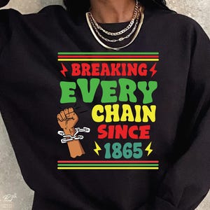 May include: Black sweatshirt with a green, yellow, and red graphic print that says "Breaking Every Chain Since 1865". The graphic also includes a raised fist with a chain around the wrist.