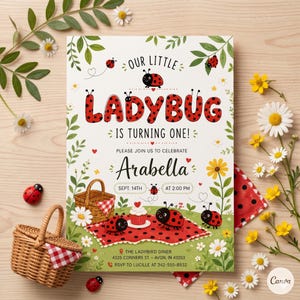 May include: A ladybug-themed birthday invitation with the text "Our Little Ladybug is Turning One!" and "Arabella" in a whimsical font. The invitation features ladybug illustrations, a picnic scene, and floral accents. A wicker basket and ladybug figurines are also present.