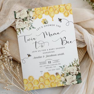 May include: Baby shower invitation with floral and honeycomb design. The invitation reads "Let's Shower the Mama to Bee" and includes the names Amelia & Jacobson Smith, date, time, and address.