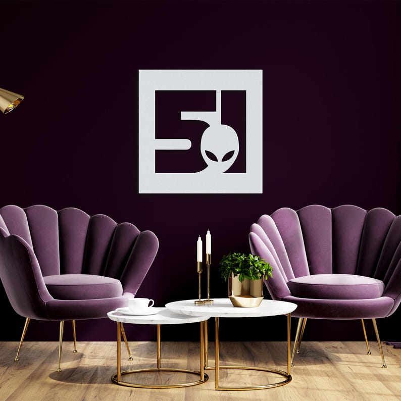 A metal sign depicting the number 51 and a head of a stylised alien, square shape and silver colour.