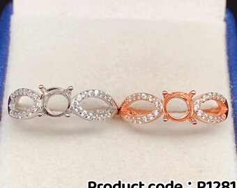 Könnte beinhalten: Zwei Ringe aus Sterlingsilber mit einer runden Fassung von 6x6mm. Der Ring links ist silber, der Ring rechts ist roségold. Beide Ringe sind mit kleinen, klaren Steinen besetzt.