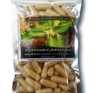 Può includere: Un sacchetto argentato richiudibile riempito con 90 capsule marroni etichettate "Ashwagandha 400mg Withania somnifera (2.5 Withanolides) 90 Capsule Dosaggio: una capsula assunta 2-3 volte al giorno." Il sacchetto ha un'etichetta con una pianta verde e il testo "HEALTHTONICS.CO.UK" e una data di scadenza del 23-9-2016.