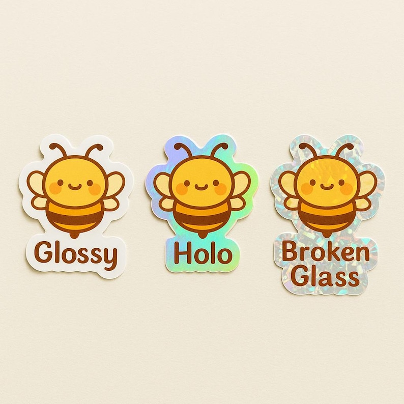 May include: Three bee-themed stickers with different finishes. The first is labeled "Glossy", the second "Holo", and the third "Broken Glass". Each sticker features a smiling cartoon bee in yellow and brown.