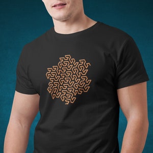 Könnte beinhalten: Ein schwarzes T-Shirt mit einem braunen geometrischen Muster in Form einer Blume.