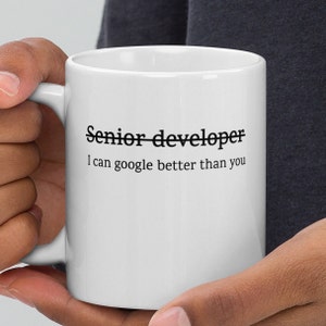 Puede incluir: Taza de cerámica blanca con texto negro que dice "Senior developer I can google better than you".