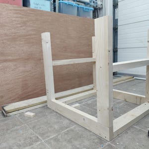May include: A wooden frame for a shelf unit, constructed from unfinished pine wood. The frame is assembled and ready for shelves to be added.