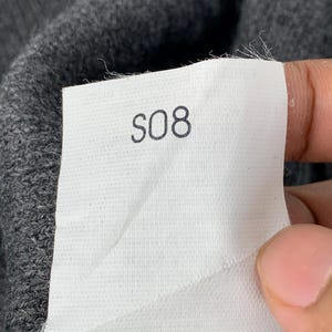 Puede incluir: Una etiqueta blanca con el n&uacute;mero "S08" impreso en negro.