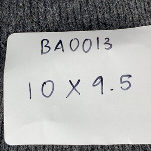 Puede incluir: Una etiqueta blanca con texto escrito a mano en negro que dice "BA0013 10 X 9.5".
