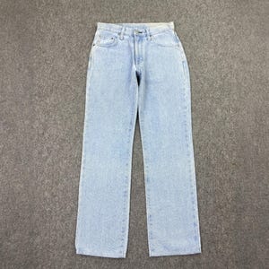 May include: Light blue denim jeans with a classic five-pocket design. The jeans have a straight leg cut and a button and zipper closure. The denim has a faded, stonewashed appearance.