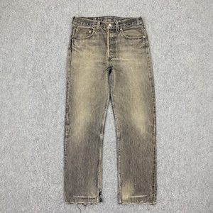 May include: A pair of faded brown denim jeans with a button fly and five pockets.