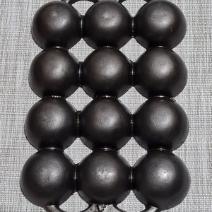 May include: A cast iron baking pan with 15 round depressions, perfect for making individual cakes or muffins. The pan has two handles on the sides.