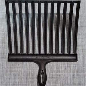 May include: A black cast iron grill rake with a long handle. The rake has 12 tines and a rounded handle.