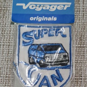 May include: A white embroidered patch with blue lettering that reads "SUPER VAN". A blue van is embroidered in the center of the patch. The patch is packaged in a clear plastic bag with a blue and white label that reads "Voyager originals" and "MADE IN U.S.A."
