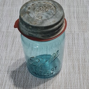 May include: A vintage blue Ball Perfect Mason jar with a metal lid. The lid has a red rubber ring and the Ball logo is visible on the lid.