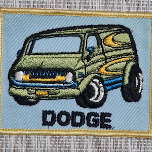 May include: A green and yellow embroidered patch of a Dodge van with the word "DODGE" below it.