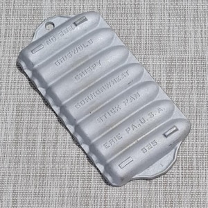 May include: A vintage silver Griswold stick pan for making cornbread. The pan is labeled "No. 323", "Griswold", "Crispy", "Cornbread Wheat", "Stick Pan", "Erie Pa. U.S.A.", and "825".