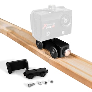 May include: A black wooden train engine with a camera mount for an action camera. The camera is mounted on the engine and is facing forward. The engine is on a wooden track. The camera has the text "Xtreme 1+ UHD 4K" on it. The engine has two black wheels on each side. The engine also has a small silver screw on the side. The engine is made of wood and has a black finish. The engine is a toy and is designed to be used with a toy train set.