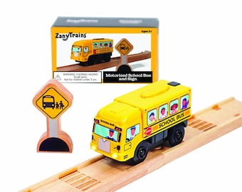 Puede incluir: Un autobús escolar de juguete amarillo con ruedas negras y una señal de stop, sobre vías de tren de madera. El autobús tiene ventanas con ilustraciones de niños. También se incluye una señal con un símbolo de autobús escolar. La caja dice "ZanyTrains".