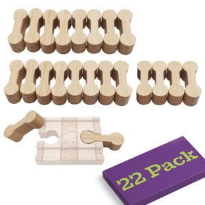 May include: A set of 22 wooden puzzle pieces in the shape of a bone. The pieces are arranged in rows and are all the same size and shape. The pieces are light brown in color and have a smooth finish. The set comes in a purple box with the text "22 Pack" printed in green letters.