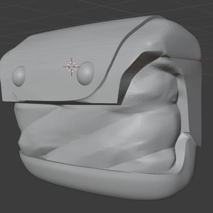 K&ouml;nnte beinhalten: Ein graues, 3D-gedrucktes Modell eines kleinen, kastenf&ouml;rmigen Objekts mit abgerundeter Oberseite und zwei kreisf&ouml;rmigen Vertiefungen an der Vorderseite. Das Objekt hat eine strukturierte, wellenf&ouml;rmige Oberfl&auml;che und einen glatten, flachen Boden.