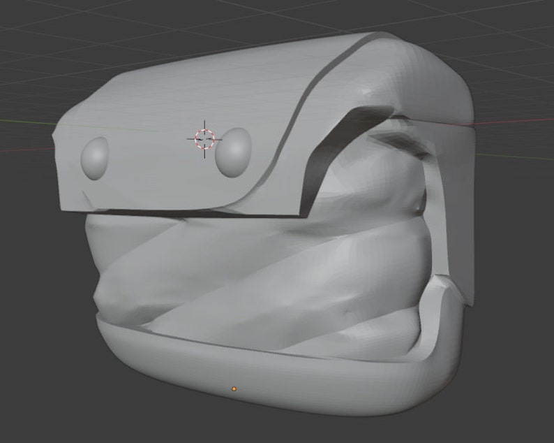 K&ouml;nnte beinhalten: Ein graues, 3D-gedrucktes Modell eines kleinen, kastenf&ouml;rmigen Objekts mit abgerundeter Oberseite und zwei kreisf&ouml;rmigen Vertiefungen an der Vorderseite. Das Objekt hat eine strukturierte, wellenf&ouml;rmige Oberfl&auml;che und einen glatten, flachen Boden.