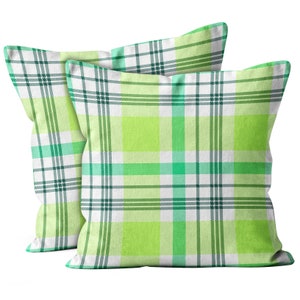 May include: Two green and white plaid throw pillows. The pillows are made of a soft, comfortable fabric and have a subtle sheen.