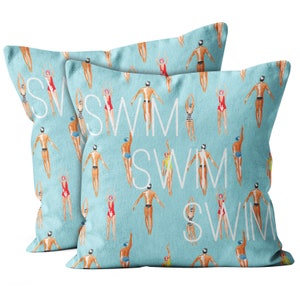 May include: Two blue throw pillows with a white repeating pattern of swimmers and the word "swim".