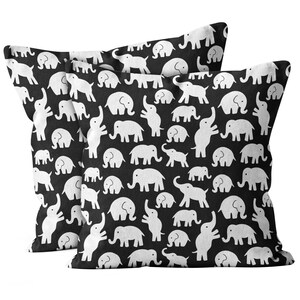 May include: Two black and white throw pillows with a repeating pattern of white elephants on a black background.