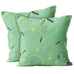 May include: Two green pillow covers with a tennis racket and tennis ball pattern.